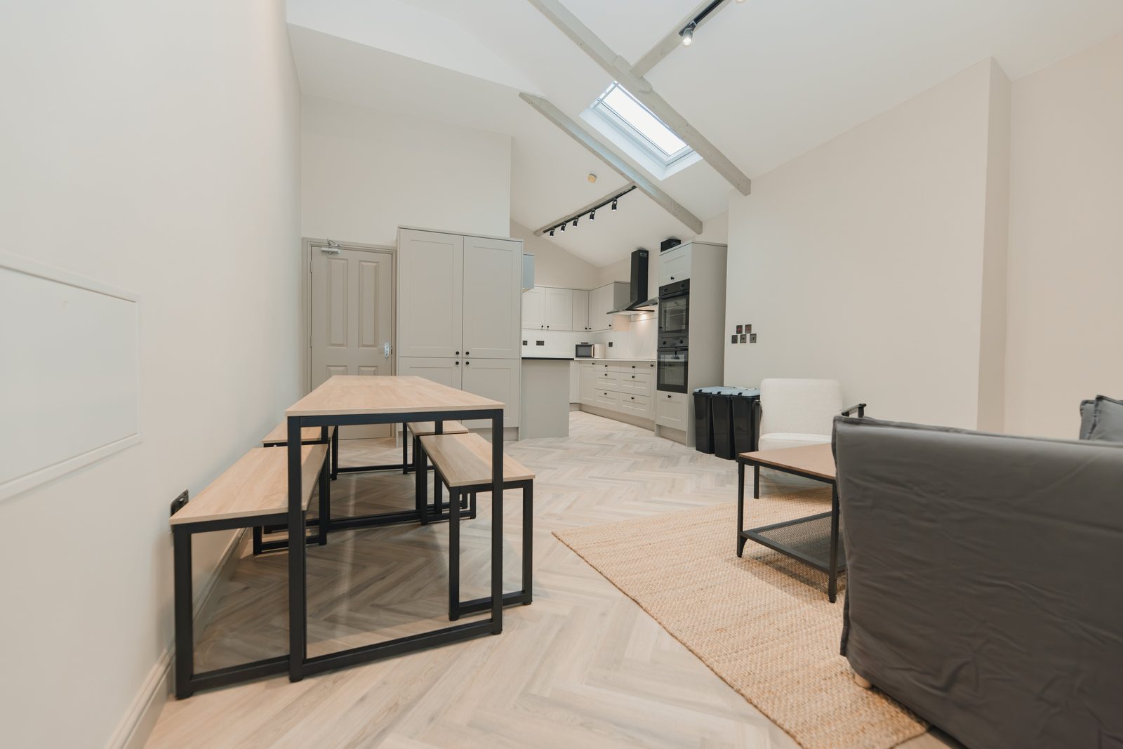 Open kitchen and dining space with vaulted ceiling and skylights