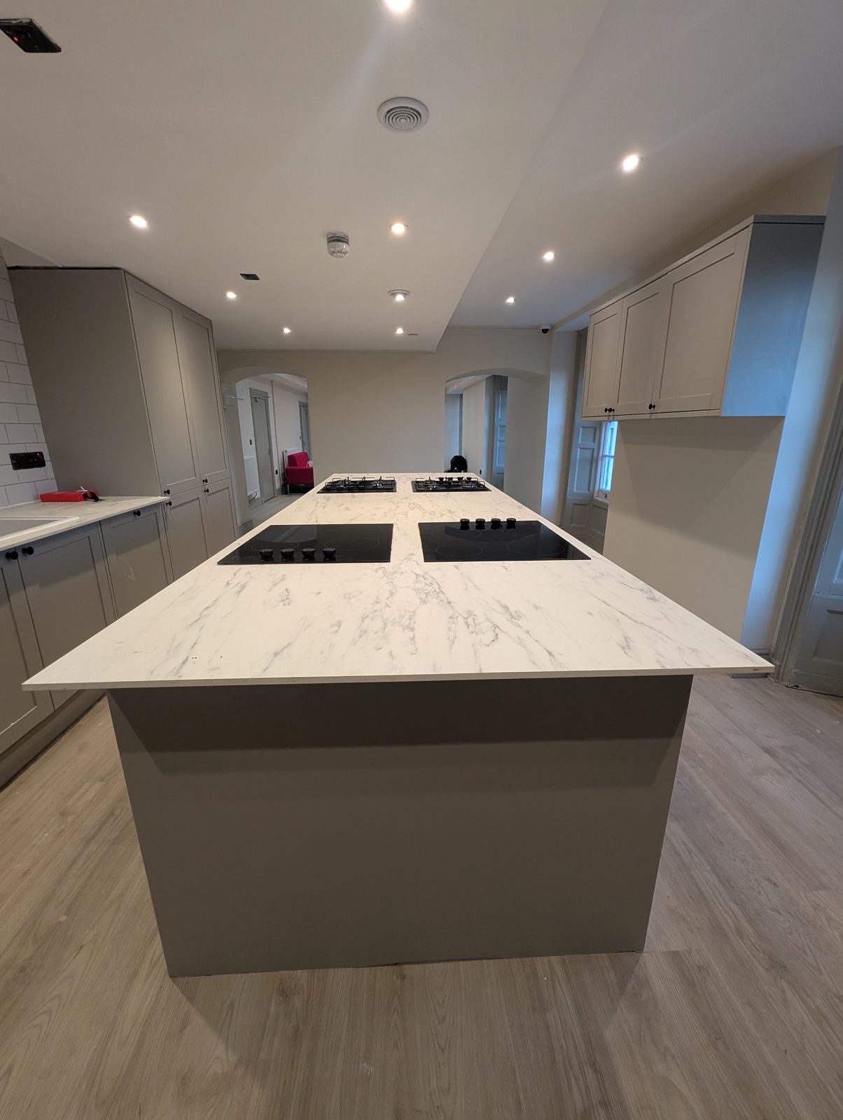 Communal kitchen island with stone worktop and multiple hobs being fitted at Mozarts
